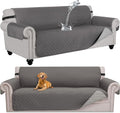 Grande housse de canapé imperméable grise matelassée, chien couché dessus, eau qui perle