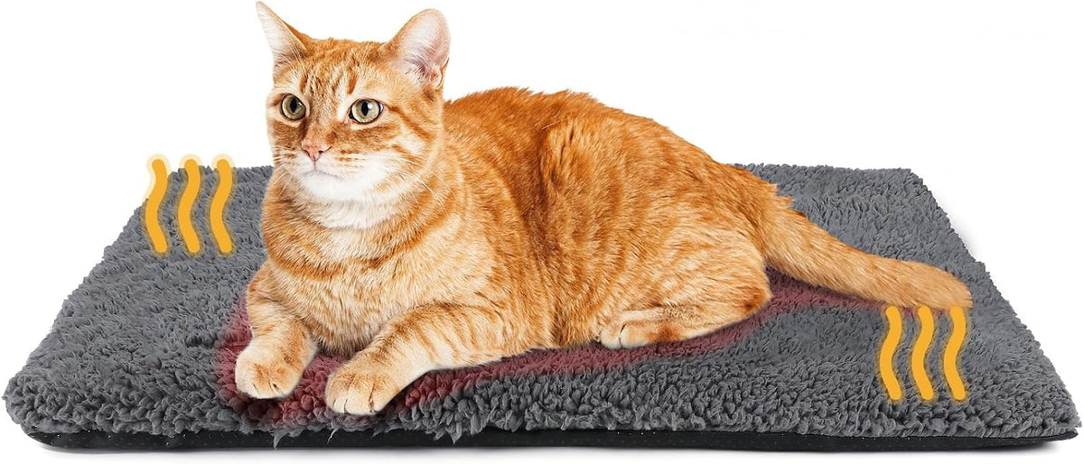 Chat roux couché sur le tapis auto-chauffant gris en molleton