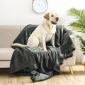 Couverture imperméable gris ardoise sur un canapé, avec un labrador assis dessus