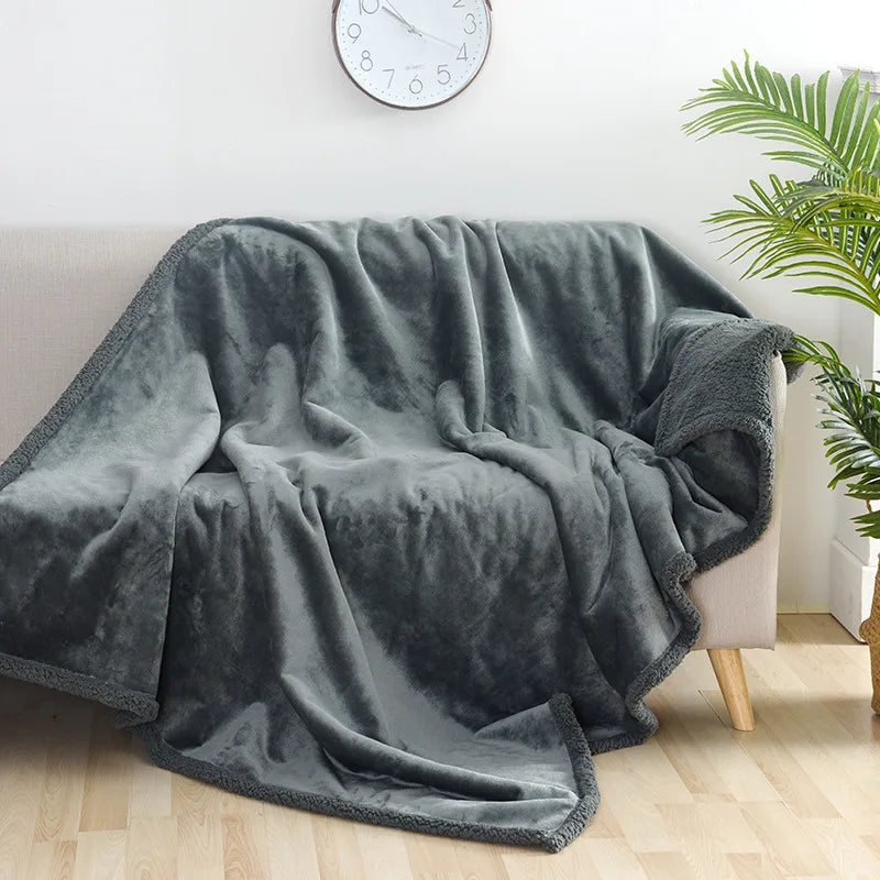 Couverture imperméable réversible gris ardoise drapée sur un canapé